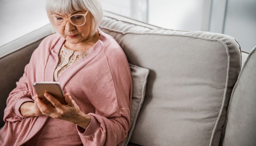 woman sitting on a couch with iphone