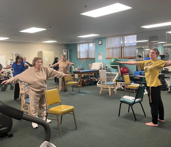 women working out doing chair aerobics with an instructor